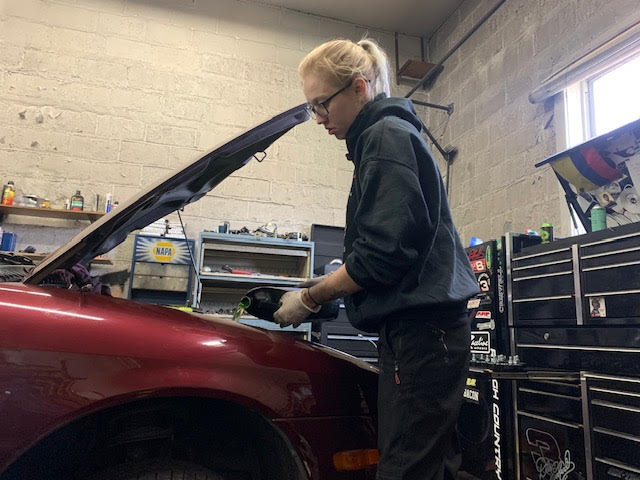 Lauren Davidson repairing an automobile